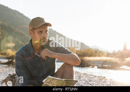 Mature man camping at riverside Stock Photo