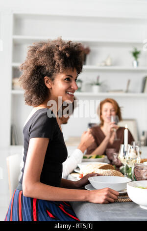 Friends having fun at a dinner party, enjoying eating together Stock Photo