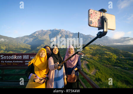 Kundasang Sabah Malaysia - Feb 28, 2019 : Group of muslim woman taking selfie using smartphone at Kudasang Sabah.Kundasang a highland in Borneo is pop Stock Photo