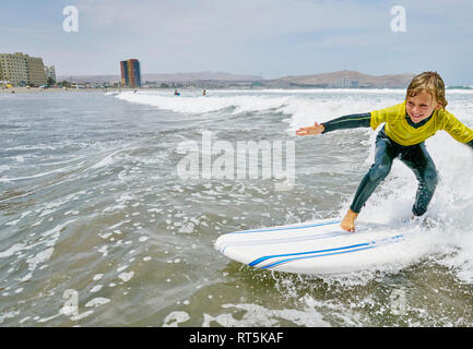 Chile, Arica, happy boy surfing in the sea Stock Photo