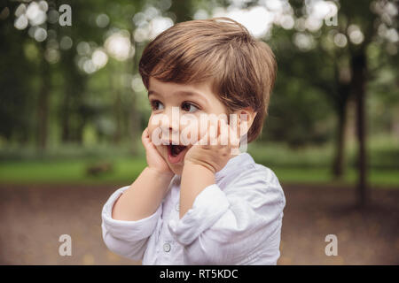 Toddler making surprised face in park Stock Photo