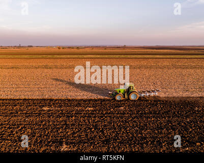 Serbia, Vojvodina. Tractor plowing field in the evening Stock Photo