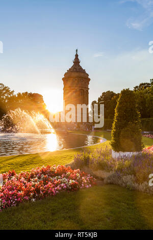 Germany, Mannheim, Friedrichsplatz with fountain and water tower in the background by sunset Stock Photo