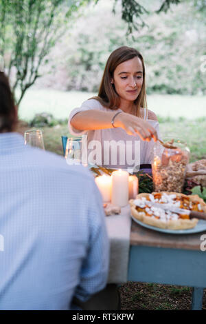 Couple having a romantic candelight meal in garden Stock Photo
