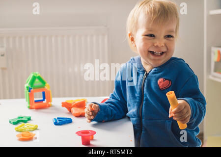 Portrait of baby girl playing with modeling clay Stock Photo