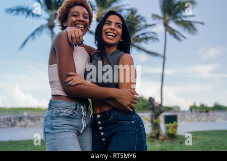 Two happy female friends hugging in a park Stock Photo