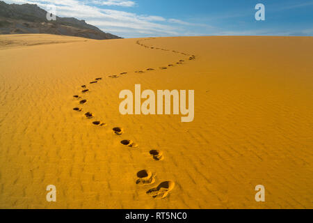 Footprints of human feet on the desert golden color sand Stock Photo