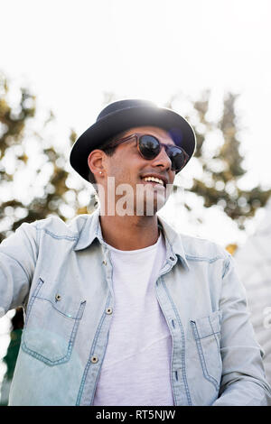 Portrait of fashionable young man wearing sunglasses and hat Stock Photo