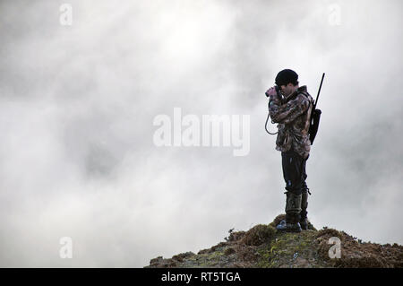 hunter looking for game animals such as chamois, deer or tahr, in  South Westland's Southern Alps, New Zealand Stock Photo