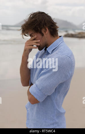 Worried man standing on the beach Stock Photo