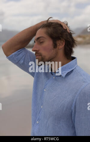 Worried man standing on the beach Stock Photo