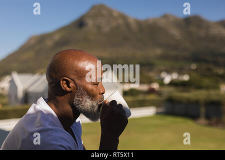 Senior man having coffee on the balcony Stock Photo