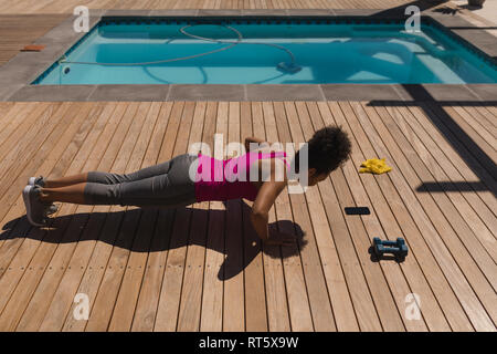 Woman performing push-up exercise in the backyard of home Stock Photo