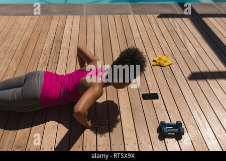 Woman performing push-up exercise in the backyard Stock Photo