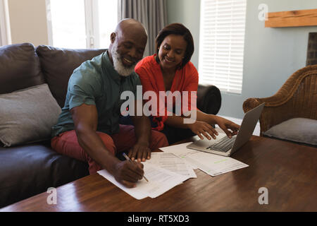 Senior couple using laptop in living room Stock Photo