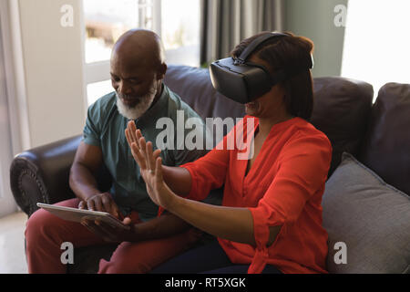 Senior couple using digital tablet and virtual reality headset Stock Photo