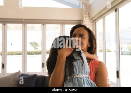 Grandmother and granddaughter embracing each other in living room Stock Photo