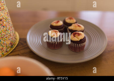 Cupcakes in a plate on a table at home Stock Photo