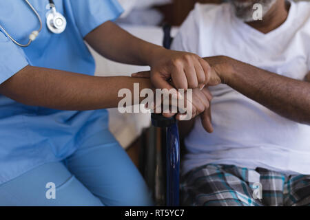Female doctor consoling senior man at home Stock Photo