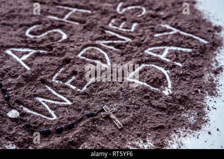 Ash wednesday word written in ash and christian cross on chaplet symbol as a religion concept Stock Photo