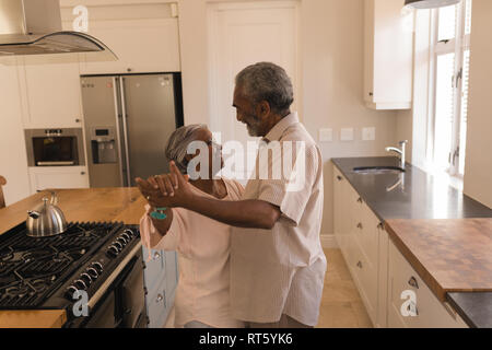 Senior couple dancing in a kitchen Stock Photo