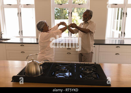 Senior couple dancing in a kitchen Stock Photo