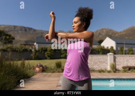 Woman performing stretching exercise in the backyard of home Stock Photo
