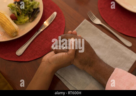 Father and daughter praying before having meal Stock Photo