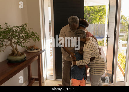 Grandparents embracing their grandchildren at home Stock Photo