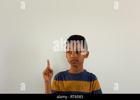 Thoughtful boy pointing his finger up Stock Photo