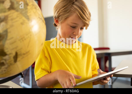 Boy using digital tablet in a classroom Stock Photo