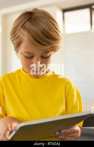 Front view of boy using digital tablet in a classroom Stock Photo