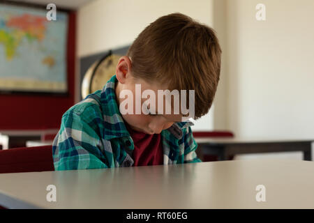 Boy sleeping at desk in classroom Stock Photo