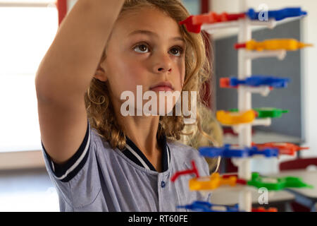 Schoolgirl learning on science model in classroom Stock Photo