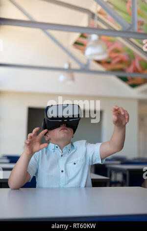 Schoolboy using virtual reality headset in a classroom Stock Photo