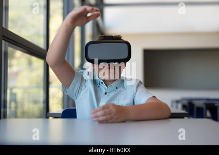 Schoolboy using virtual reality headset in a classroom Stock Photo