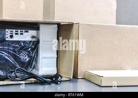 unpacking black personal computer, back view, cellophane packaging. many boxes for desktop hardware parts. Stock Photo