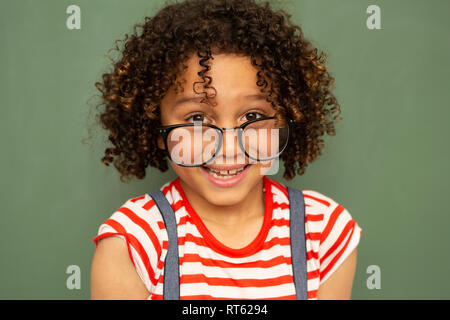 Schoolgirl standing against green board in a classroom at school Stock ...
