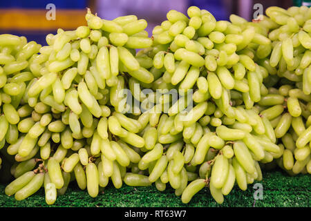 fresh natural wild tropical cluster of sweet Asian green raw ripe grapes berry fruit from garden on farmer market stall. Seasonal Food Nutrition, Summ Stock Photo