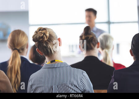 Businesswoman listening to speech at a business seminar Stock Photo