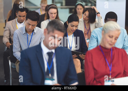 Young businesswoman reading document in a business seminar Stock Photo