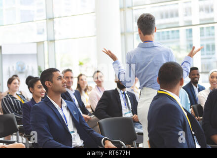 Businesswoman asking question during seminar Stock Photo