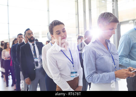 Business people standing in queue in lobby Stock Photo