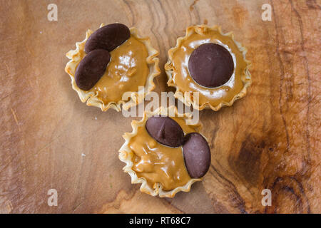 baked phyllo dough cups filled with peanut butter topped with dark chocolate wafers Stock Photo