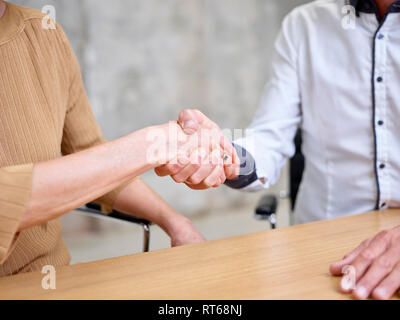 Close-up of businessman and businesswoman shaking hands Stock Photo