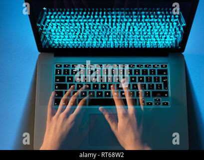 Hands of hacker coding computer virus on laptop Stock Photo