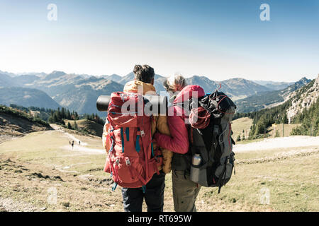 Austria, Tyrol, rear view of couple on a hiking trip in the mountains enjoying the view Stock Photo