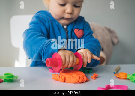 Baby girl playing with modeling clay Stock Photo