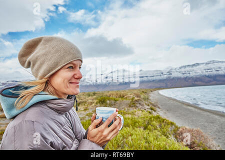 Argentina, Lago Posadas, woman holding mug at lakeside Stock Photo
