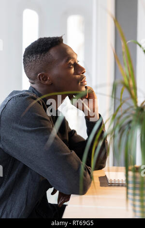 Pensive businessman sitting at dek in his office Stock Photo